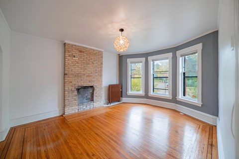 A room with a fireplace and wooden floors.